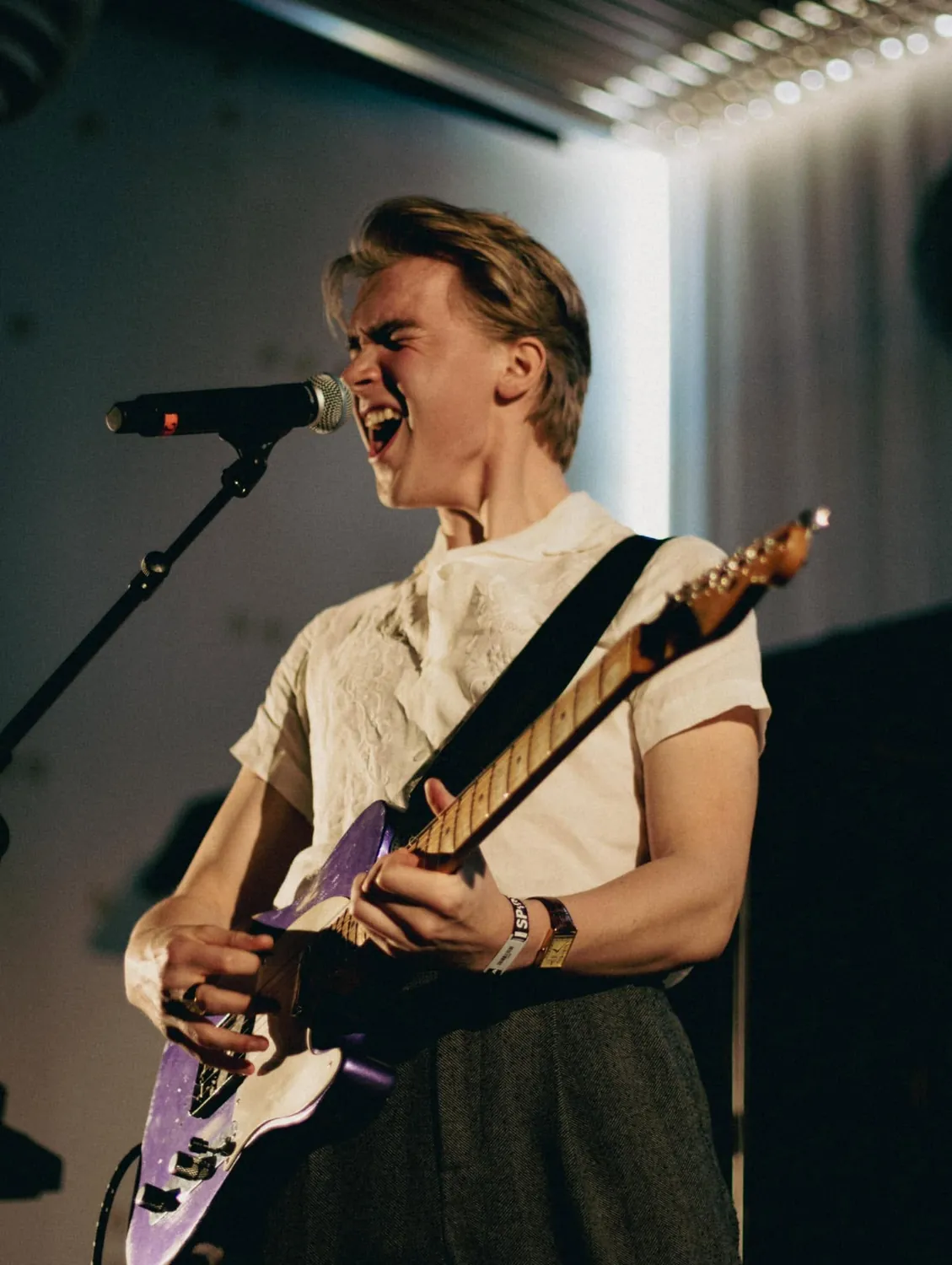 Musiker med guitar i hvidt scenelys