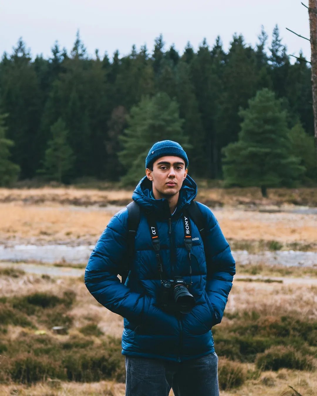 Fotograf med kamera om halsen i efter&aring;rslandskab